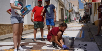 Los jóvenes cofrades alfombran de sal la calle Carmen para el paso de la Patrona