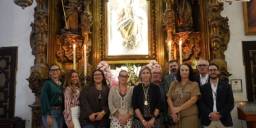 Los hermanos de Columna encargados de adecentar el altar de la Virgen del Rosario en la Iglesia Mayor