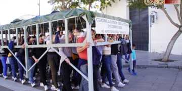 La cuadrilla de cargadores de Cristo Rey se prepara en la Bazán para el Domingo de Ramos